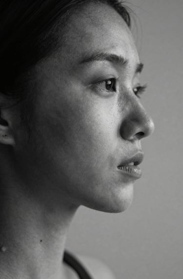 Detailed study of light and shadow on a human subject in a North American studio. Elegant composition emphasizing shape and essence. Black and white aesthetic with rich charcoal values.