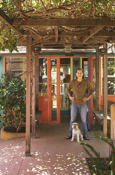 Artist Tal Avitzur with canine friend Milo at entrance to home gallery.