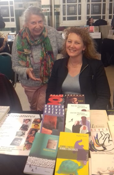 Sophie Stern écrivaine avec son éditrice dans un salon du livre, assise une table avec ses livres