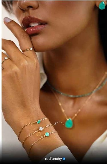 a woman wearing a white shirt and green jewelry