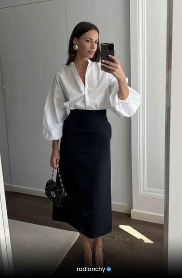 a woman in a white shirt and black skirt