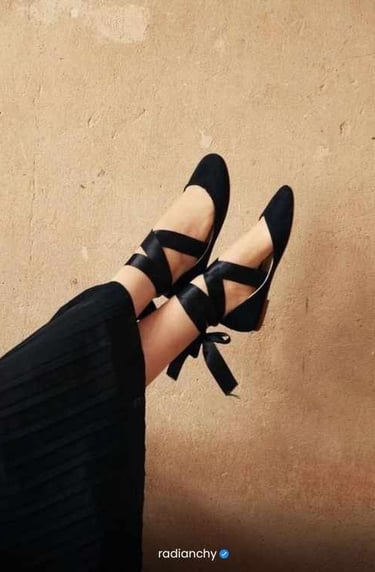 a person wearing black shoes and a black dress