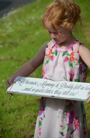Young girl holding a sign for Mommy & Daddy