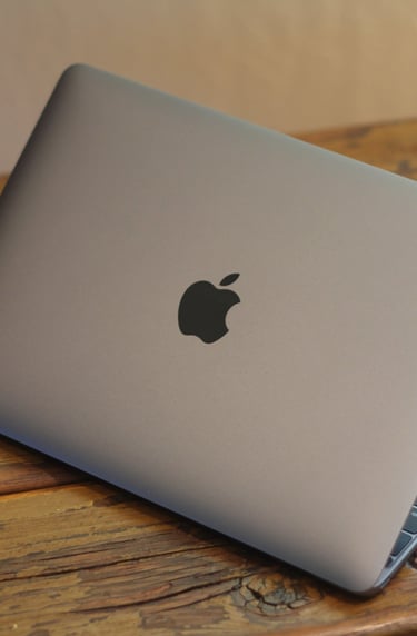 a laptop computer sitting on a wooden table