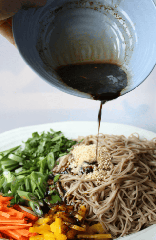 pouring sauce on Potluck Soba Salad