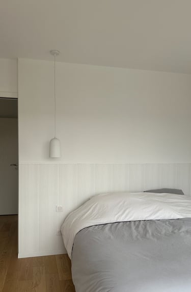  a white bed and a white lamp