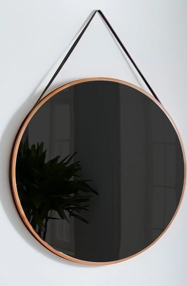 A mirror hangs on a wall with a darkened reflection, prompting the viewer to see their face