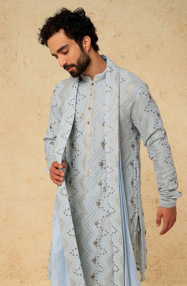 a man in a blue and white indian wedding suit