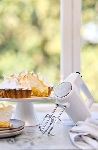 Food product photography - a cake with a mixer on a marble bench