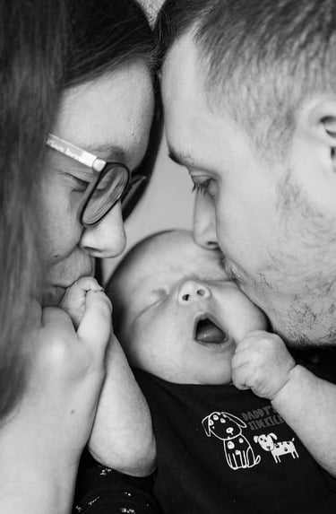 Deux parents faisant un bisou à leur bébé