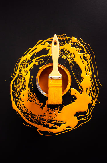 photo artistique d'un pinceau jaune ave autour de la peinture jaune également