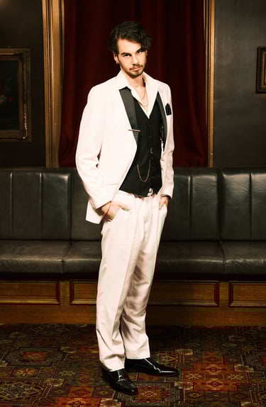 a man in a white suit and black tie