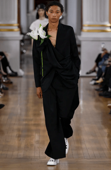 Simone Rocha model in black draped suit with floral detail on the runway at London Fashion Week 2026