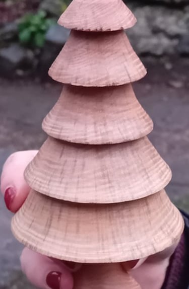 Hand holding a turned wooden fir tree