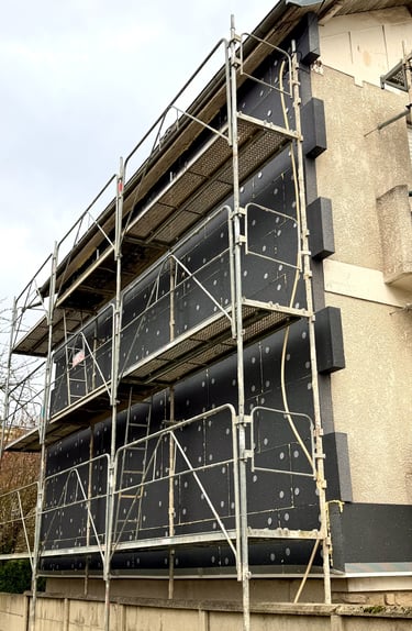 chantier en cours façade de maison avec pose de plaques isolantes et chevilles