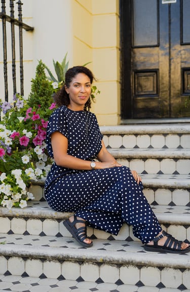 woman sitting on the stairs with flowers around her and smiling