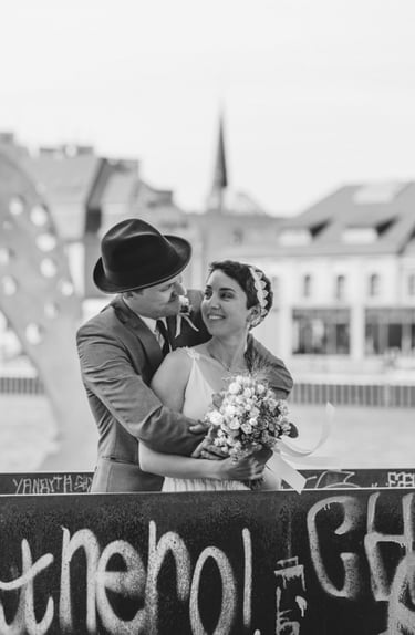 Der Bräutigam umarmt die Braut von hinten.