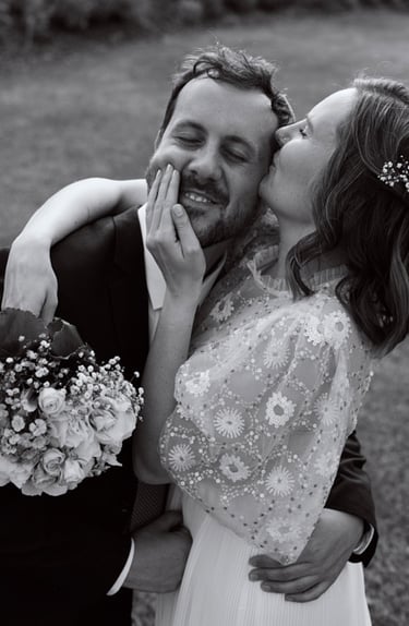 Braut küsst Bräutigam auf die Stirn.