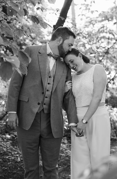 Bride and groom walking in a park.