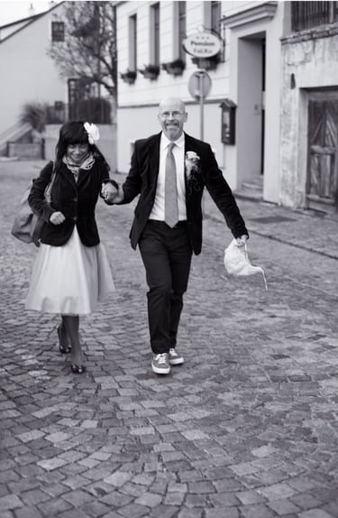 Braut und Bräutigam spazieren auf einer gepflasterten Straße.