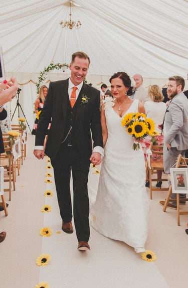 Braut und Bräutigam gehen nach der Zeremonie den Gang entlang.