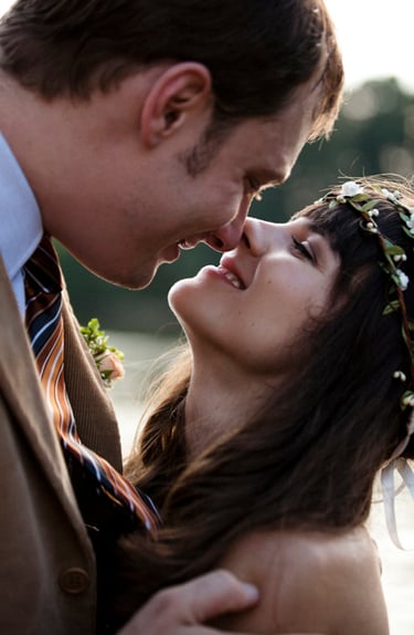 Braut und Bräutigam berühren sich gegenseitig die Nasen.