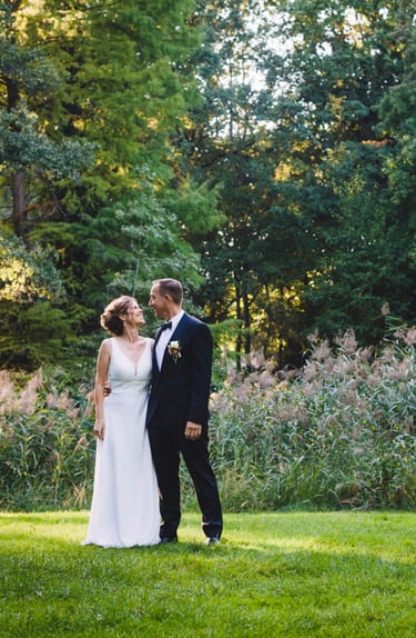 Reife Jungvermählte stehen in einem Park.