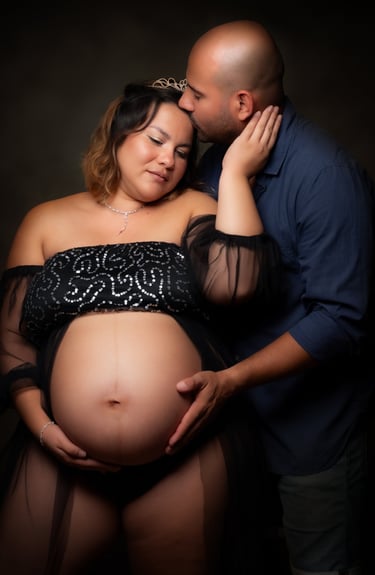 a pregnant woman is holding her belly while a man kisses her belly