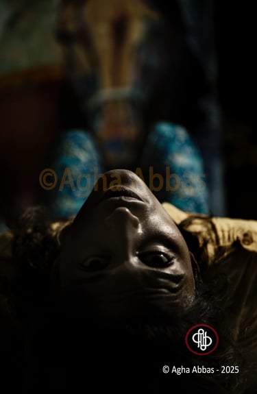 A person wearing blue patterned pants is lying down on a bed, with their legs up in the air and a bl