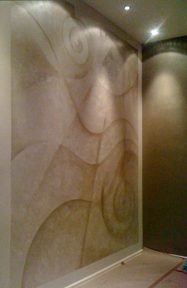 A room with abstract mural in silver paint featuring lines and wavy curves.