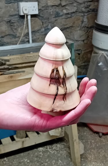 A turned wooden fir tree standing on a hand