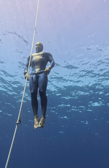 A Freediver using buoyancy to ascend towards the surface along a dive line
