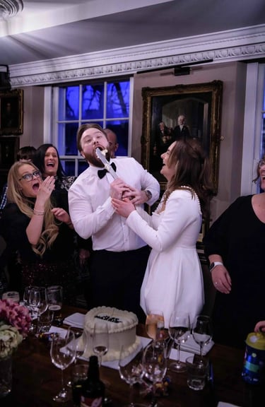 Jake and Aimee having fun cutting their wedding cake