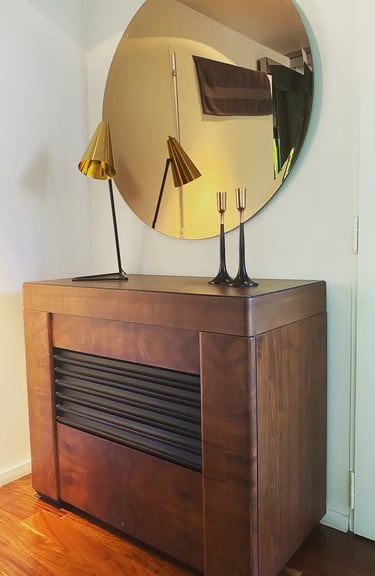 Mueble de diseño, espejo redondo y lámparas de diseño componiendo un espacio único y con clase.