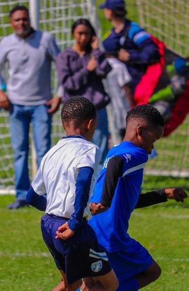 two boys playing soccer on a soccer field