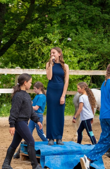 a girl in a blue dress standing on a blue blanket