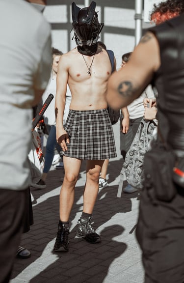 Partially shirtless cosplayer in a plaid skirt and futuristic helmet at an event in Bilbao, Spain. Unique and bold convention