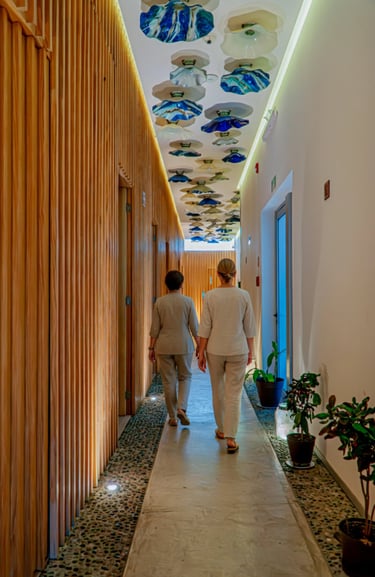 two people walking down a hallway with a ceiling fan