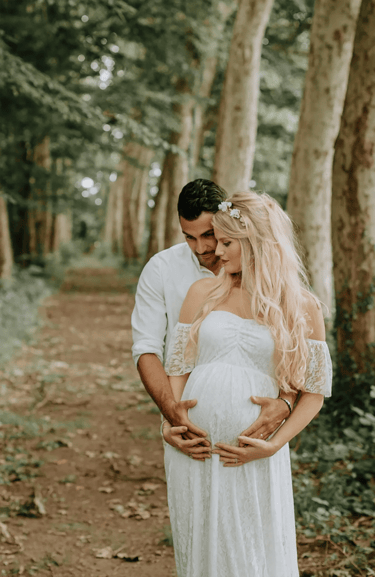 un couple dont la femme est enceinte pose pour une séance photo