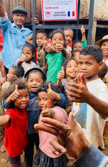 a group of children and adults standing in front of a sign