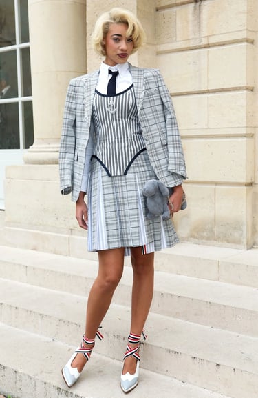 Reign Judge at Paris Fashion Week 2026 in grey suit.