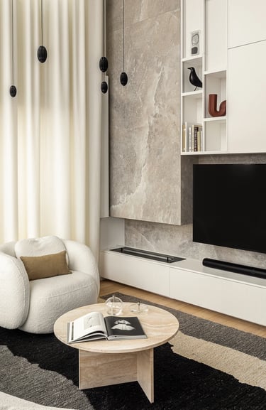 Salon z brązową sofą Togo, fotelem boucle i kamienną ścianą TV.