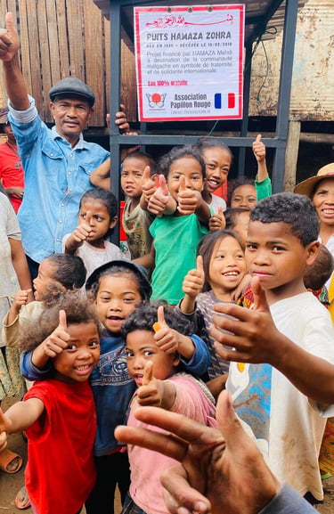 a group of children and adults standing in front of a sign