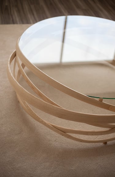 vue de haut d'une grande table basse en lattes de bois étuvé avec un plateau en verre