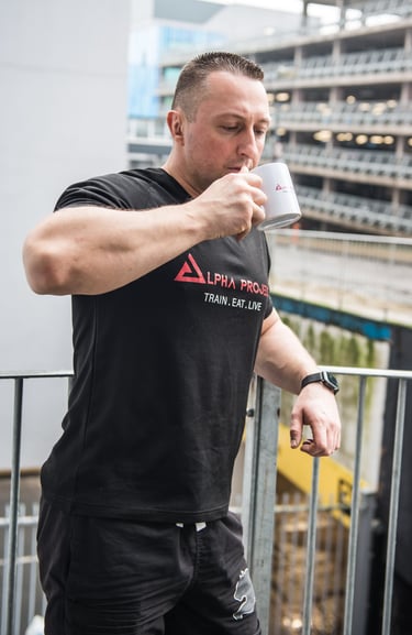 a man drinking a cup of coffee on a balcony