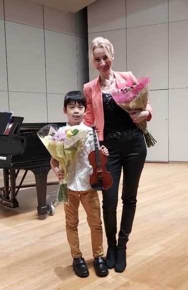 Violin student with his violin teacher after a successful concert