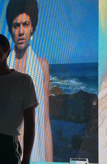 una mujer afrodescendiente en un escenario delante de una pantalla con otra mujer afrodescendiente