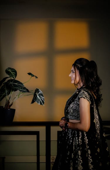 Side profile Indian bride wearing elegant black lehenga with professional bridal makeup and soft cur