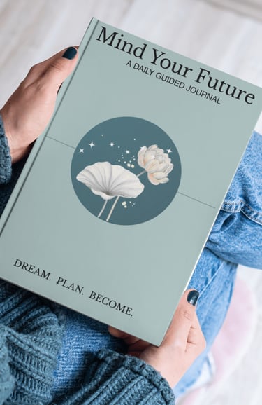 Person holding Mind Your Future daily guided journal with a lotus flower design.