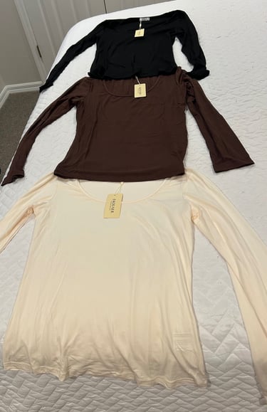 Set of three Ekouaer long sleeve shirts in black, beige, and brown laid out flat.